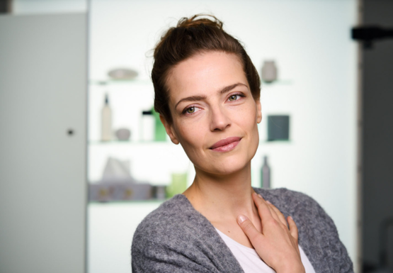 Frau hat Hand am Hals wegen einer Halsentzündung